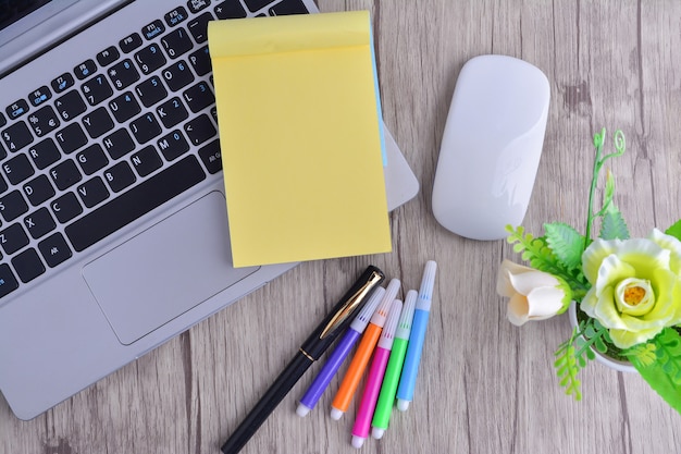 Laptop, notebook with magnifying glass on wooden table