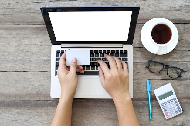 Laptop or notebook on wooden work table and white card in hand of business man.