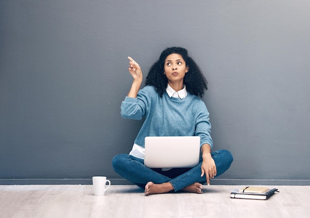 Laptop research and pointing with black woman on floor with mockup for social media news or deal Offer online shopping and technology with girl customer for communication internet or advertising