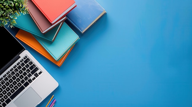 A laptop and stack of textbooks sit on a blue desk symbolizing modern learning methods and online courses Generative AI