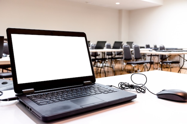 Laptop on table with white screen mock up in the training room