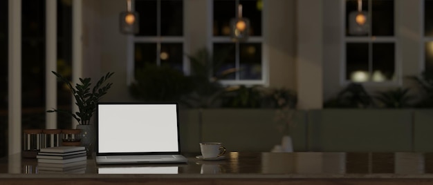 A laptop white screen mockup on a tabletop in modern comfortable room at night