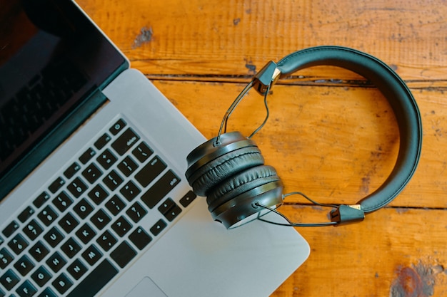 Laptop and wireless headphones on wooden table modern gadgets workspace of freelance flat lay of not...