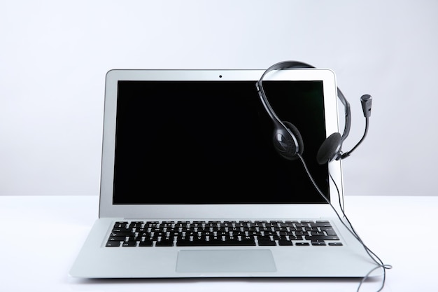 Laptop with headset on white table