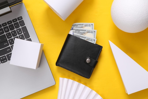 Laptop with a purse and geometric shapes on a yellow background Top view