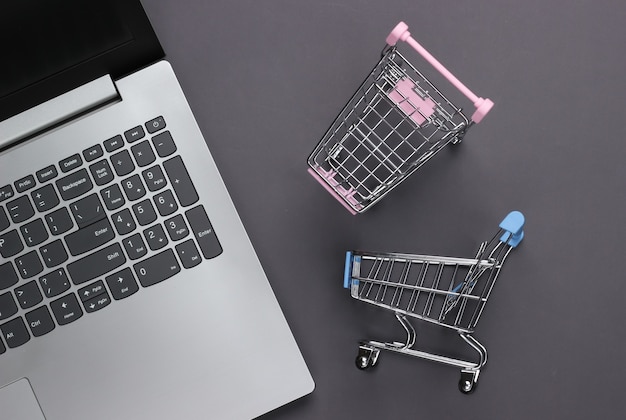 Laptop with supermarket trolleys on gray