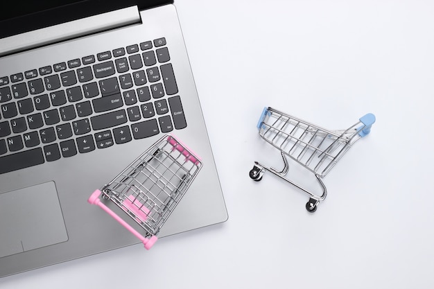 Laptop with supermarket trolleys on white