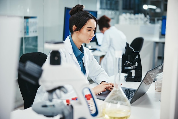 Photo laptop woman and medical scientist in laboratory with online research for cancer clinical trial science computer and female biologist with pharmaceutical discovery for healthcare innovation