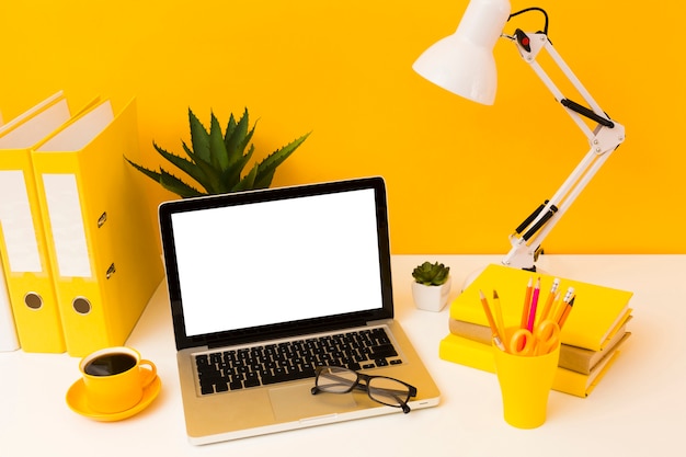 Laptop next to yellow stationery