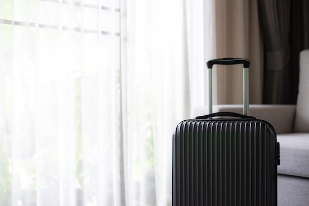 A large black suitcase sits at the foot of the bed in living room at luxury hotel