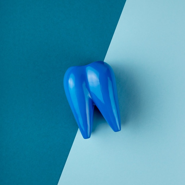 Large blue tooth lies on combined blue background