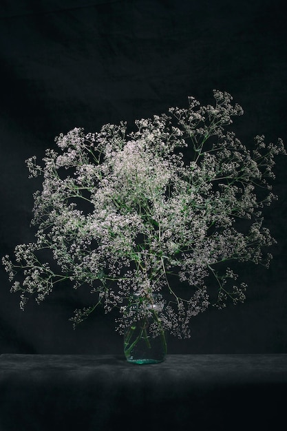 A large bouquet of wild flowers on the table in a glass vase