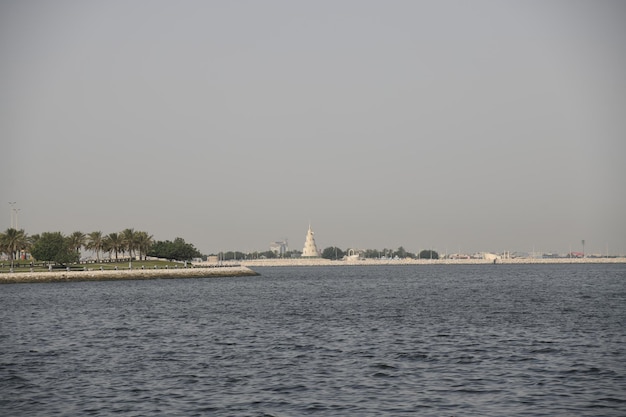 A large building is in the distance with a large white tower in the background.