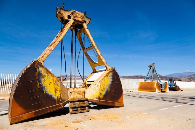 Large cargo buckets stand on the territory of the seaport for unloading and unloading bulk cargo