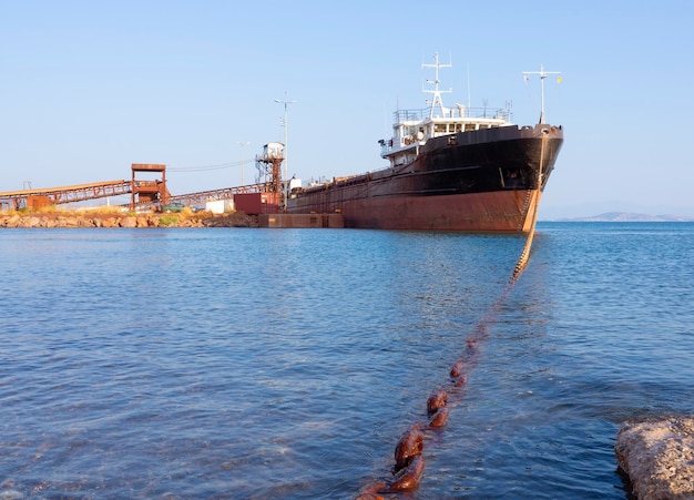 Large cargo ship - bulk carrier - is loaded in the Aegean sea on the Greek island of Evia, Greece