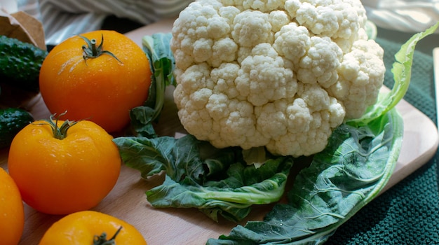 Large cauliflower tomatoes and cucumbers on a cutting board