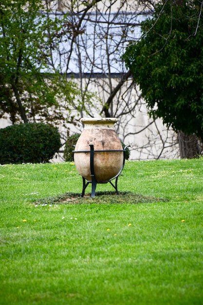 Large clay pot with a metal bottom Pot in a clearing with green grass