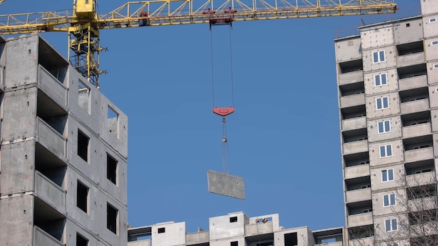 Large construction crane sets up the wall on the building building a new skyscrapper