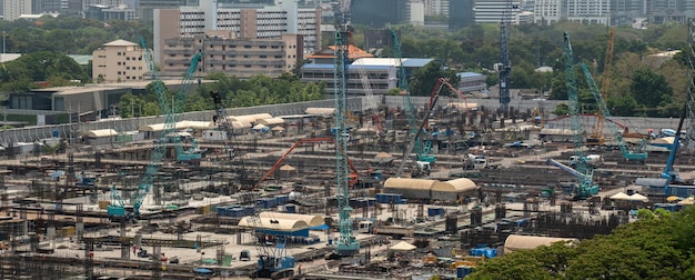 Large construction site with heavy construction machinery in metropolis