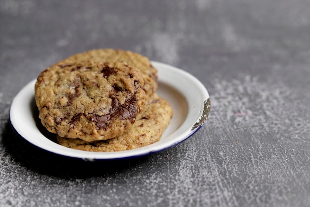 Large cookies with chocolate in a worn pewter dish