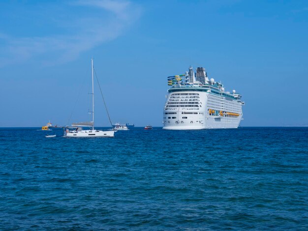 Large cruise ship and yacht in the sea port of Mykonos Island in Greece