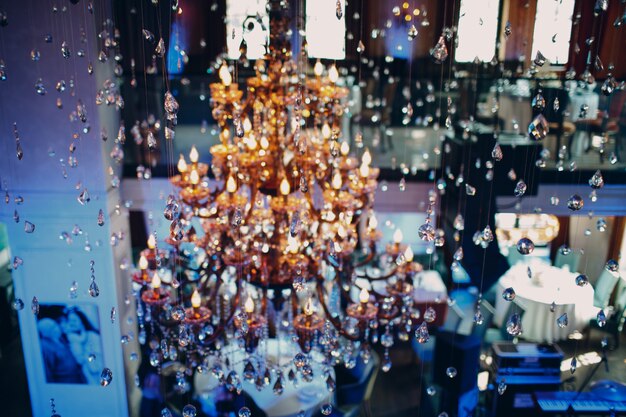 Photo large crystal chandelier illuminated with multi-colored light in the restaurant