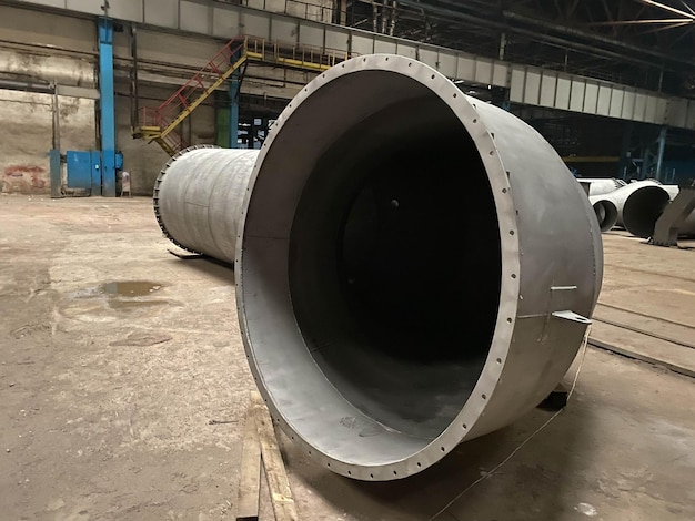 Large diameter pipes are stacked in an industrial factory shop