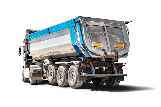 A large dump truck unloads rubble or gravel at a construction site Car tonar for transportation of heavy bulk cargo Dump truck isolated on white background