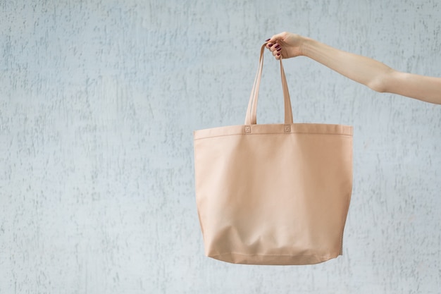 Large eco shopping bag in the hand of a young woman. Copy space