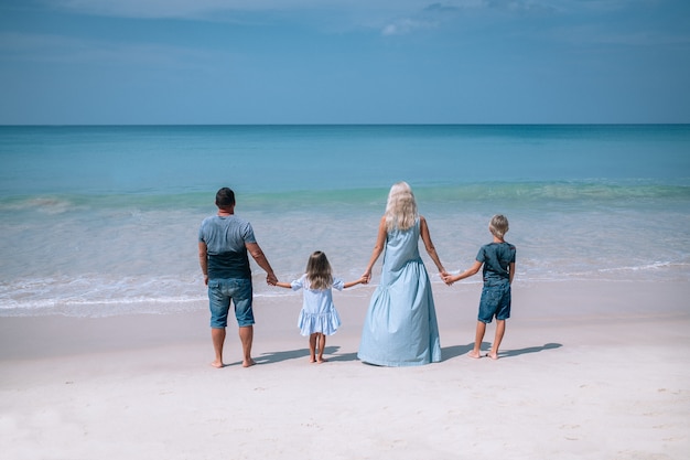 Large family holding hands and standing near the sea