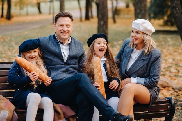 A large family is sitting on a bench in an autumn park Happy people in the autumn park