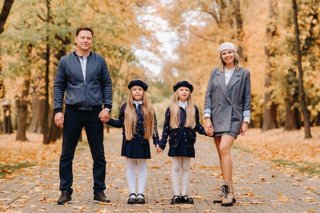 A large family walks in the park in the fall Happy people in the autumn park