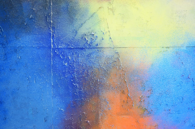 A large fragment of the graffiti pattern applied to the wall with aerosol paint. The gradient between several colors is carried out by spraying the paint. Abstract background image