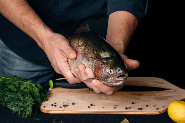 Large fresh fish in the kitchen in the hands of the chef