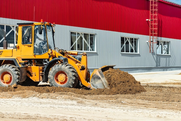 A large front loader pours sand into a pile at a construction site Transportation of bulk materials Construction equipment Bulk cargo transportation Excavation