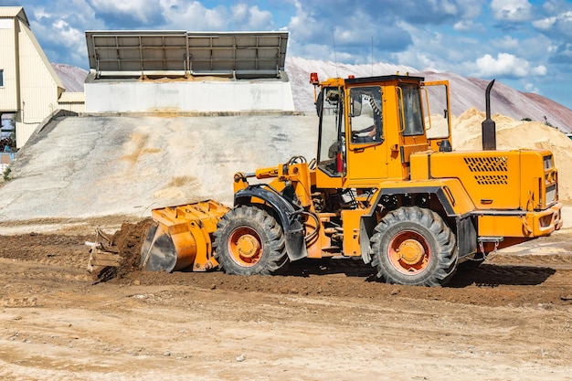 A large front loader pours sand into a pile at a construction site Transportation of bulk materials Construction equipment Bulk cargo transportation Excavation