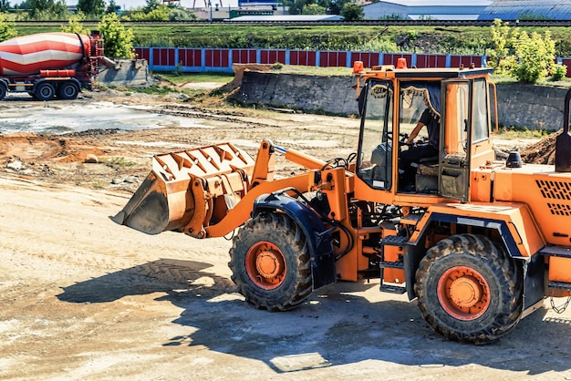 A large front loader transports crushed stone or gravel in a bucket at a construction site or concrete plant Transportation of bulk materials Construction equipment Bulk cargo transportation