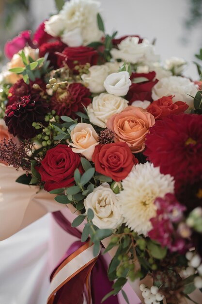 Large gift arrangement with bright red and white flowers and ribbons