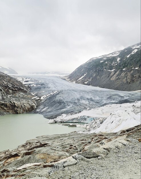 A large glacier is in the distance and the water is green.