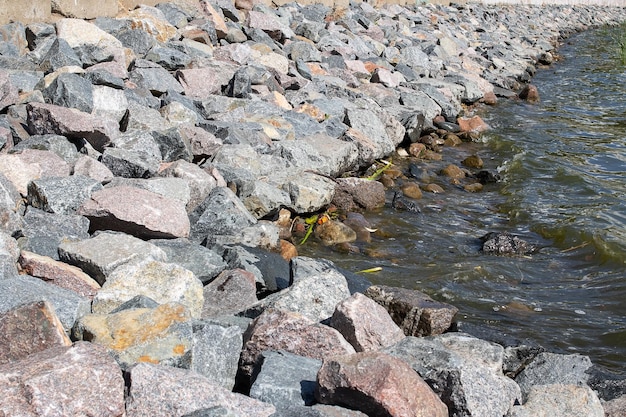 Large gray stones on the shore with waves