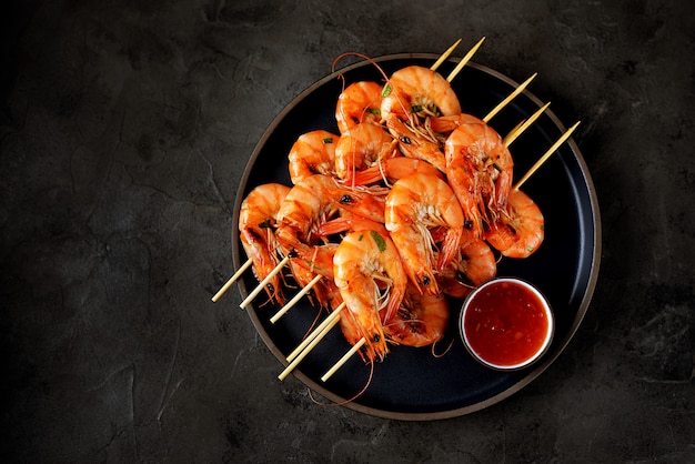 Large grilled prawns on wooden skewers. Shrimp kebabs.