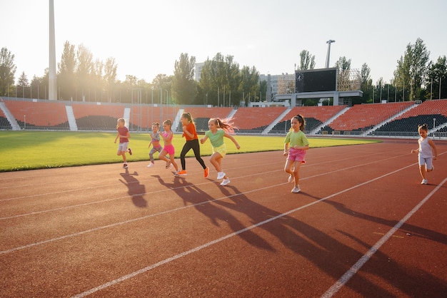 A large group of girls got ready at the start before running at the stadium during sunset A healthy lifestyle