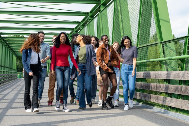 Large group of people of Generation Z young university students walking and having fun outdoor in a city park