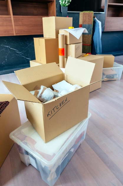 Large living room with stack of moving boxes and open kitchenware box