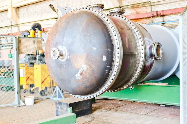 Large metal iron distillation column for separation of substances into fractions in the industrial premises of the shop at an oil refinery chemical petrochemical plant