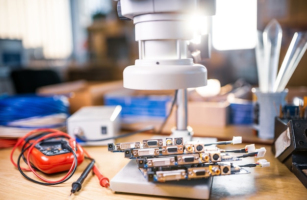 Large modern electron microscope and embedded microcircuits are stacked on test plate to prepare for the research of electronic components in a scientific laboratory