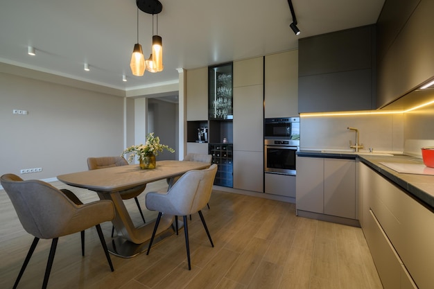 Large modern grey luxurious kitchen with dining table in studio apartment