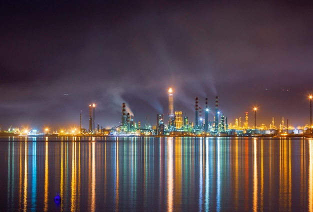 Photo a large oil refinery is lit up at night with the lights on the water