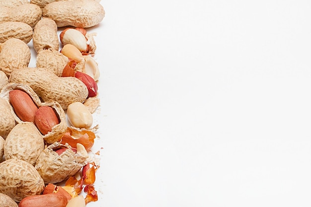 Large peeled peanuts closeup of beans in the shell Unpeeled peanuts in the shell Peanuts for background or texture Growing organic protein