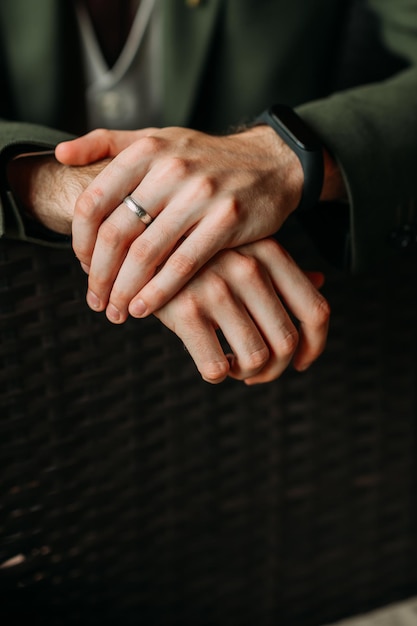 A large photo of mens hands on the back of a chair 4358